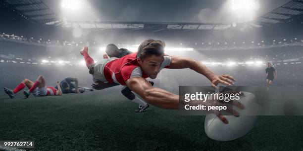 rugby-spieler in mitte luft tauchgang mit ball, partitur - rugby liga stock-fotos und bilder
