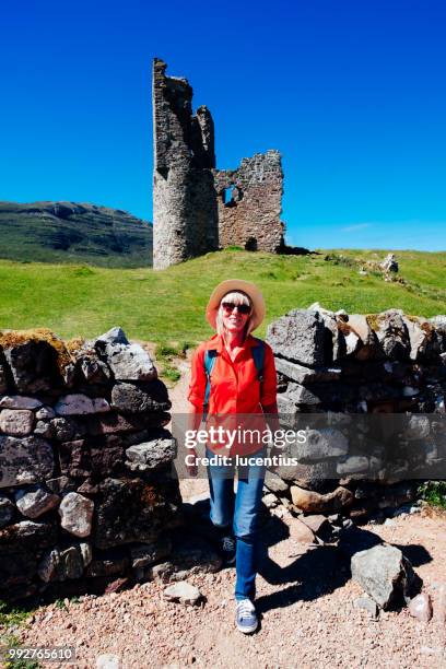 vrouw op de ruïnes van ardvreck castle, sutherland, schotland - loch assynt stockfoto's en -beelden