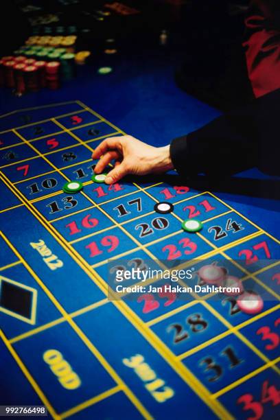 man with gambling chips on roulette table - roulette table ストックフォトと画像