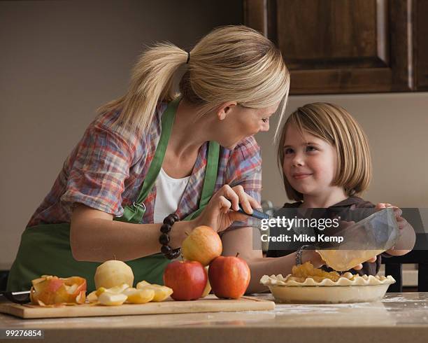 mother and daughter baking apple pie - apfelkuchen stock-fotos und bilder