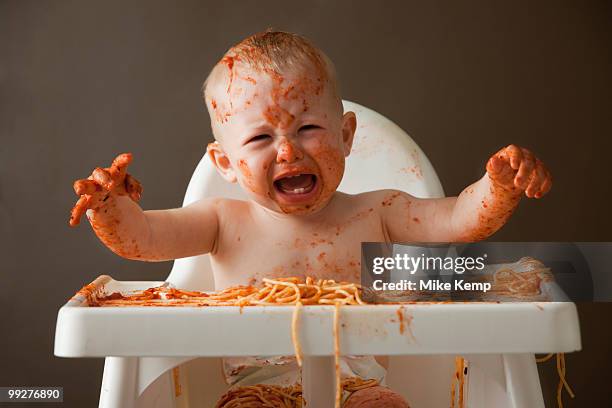 baby covered in spaghetti - baby spielt mit essen stock-fotos und bilder