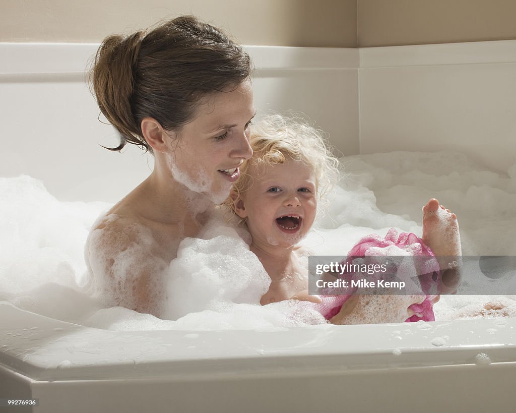 Mother and child having bubble bath