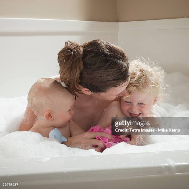 mother and children having bubble bath - mother and baby taking a bath stock-fotos und bilder