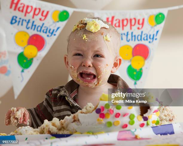 baby covered in birthday cake - sad birthday foto e immagini stock