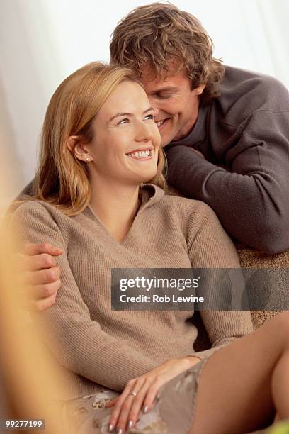 couple relaxing at home - woman whisper to man stock pictures, royalty-free photos & images