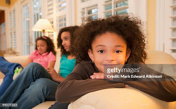 sisters on couch - mark atkinson stock pictures, royalty-free photos & images