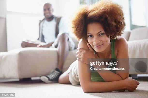 couple relaxing in living room - lying on front stock pictures, royalty-free photos & images