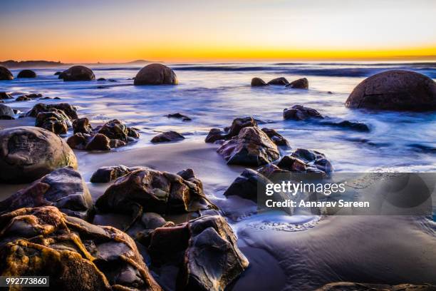 moeraki boulders at sunrise - moeraki stock pictures, royalty-free photos & images