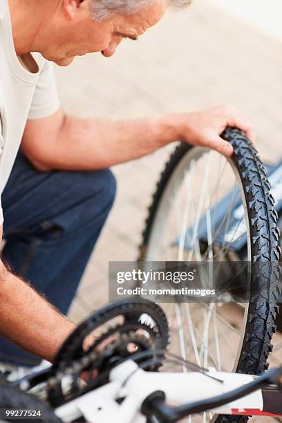 man repairing bicycle - fahrradrahmen stock-fotos und bilder