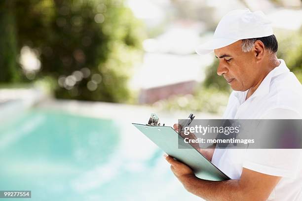 tradesman writing on clipboard - swimming pool maintenance stock pictures, royalty-free photos & images