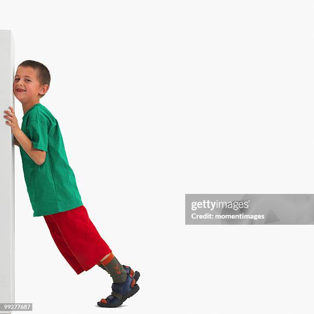 boy pushing something heavy - boy in a box stockfoto's en -beelden