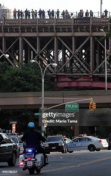 Onlookers try to get a glimpse on the Brooklyn Bridge as police keep watch while U.S. President Barack Obama visits One Police Plaza in downtown...