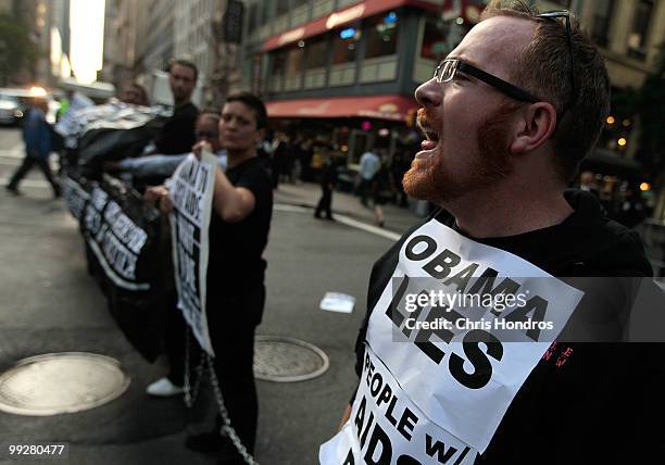 An AIDS activist shouts slogans after chaining himself to other activists and blocking Fifth Avenue near a hotel where U.S. President Barack Obama...