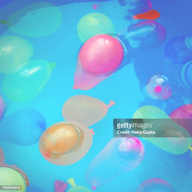 water bombs in blue bucket - neha gupta stock pictures, royalty-free photos & images