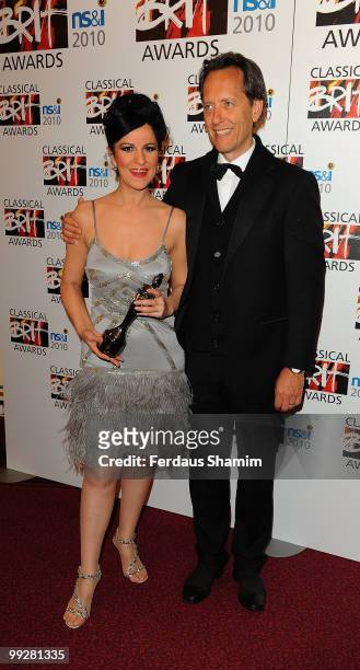 Angela Gheorghiu poses with The Female Artist of the Year Award with with Richard E Grant in the Winners Room at the Classical BRIT Awards at Royal...