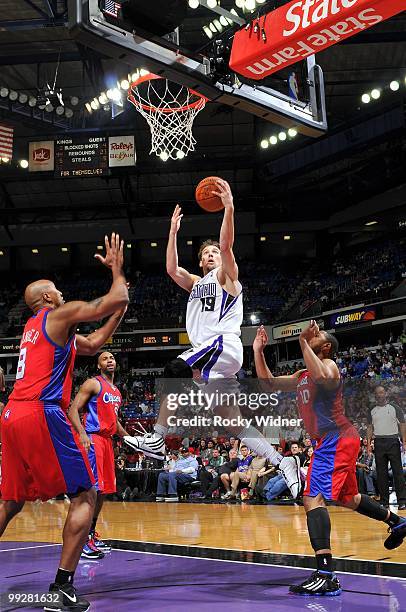 Beno Udrih of the Sacramento Kings drives to the basket for a layup against Brian Skinner and Eric Gordon of the Los Angeles Clippers during the game...