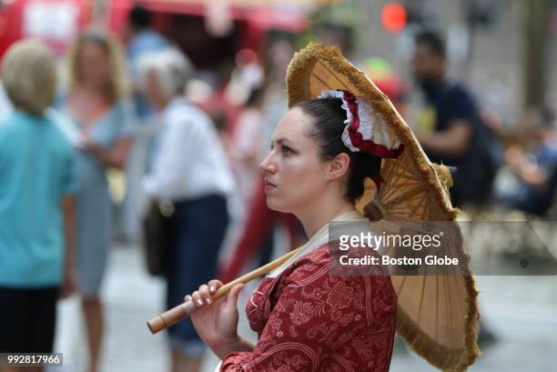 Arielle Kapland keeps cool with her parasol while waiting for the start of a Freedom Trail Tour in Boston on July 5, 2018.