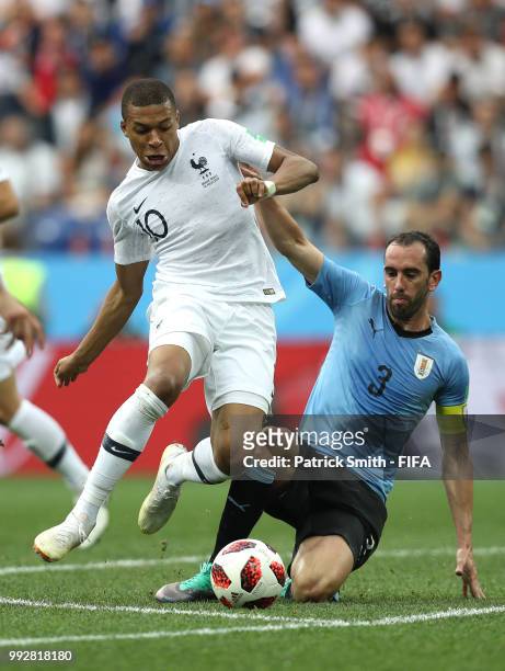 Diego Godin of Uruguay tackles Kylian Mbappe of France during the 2018 FIFA World Cup Russia Quarter Final match between Uruguay and France at Nizhny...