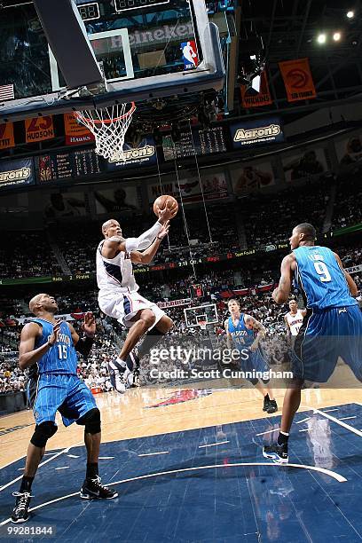 Maurice Evans of the Atlanta Hawks goes to the basket over Vince Carter and Rashard Lewis of the Orlando Magic in Game Four of th Eastern Conference...