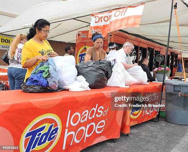 Flood victims prepare their laundry to be dropped off at the Tide's Loads Of Hope mobile laundry program at Loads of Hope Truck - Laundry Drop-Off...