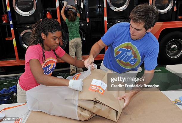 Members of the Tide's Loads Of Hope mobile laundry crew fold clean clothes at Loads of Hope Truck - Laundry Drop-Off Site: Dollar General on May 13,...