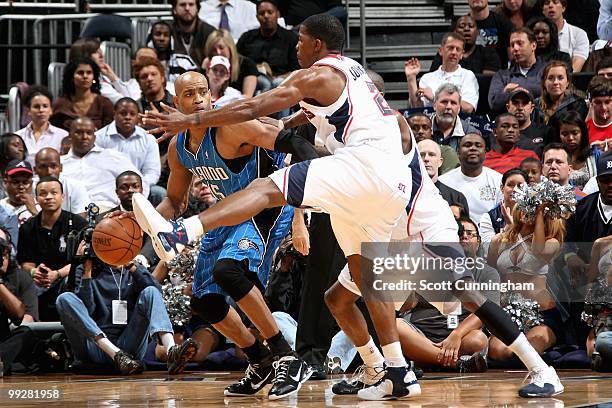 Vince Carter of the Orlando Magic passes the ball around Joe Johnson of the Atlanta Hawks in Game Four of th Eastern Conference Semifinals during the...