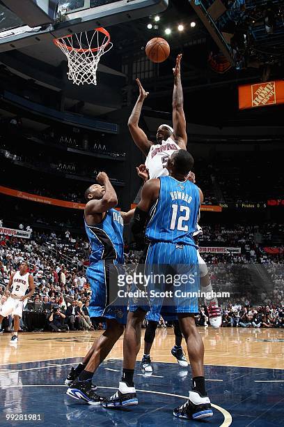 Josh Smith of the Atlanta Hawks puts a shot up over Rashard Lewis and Dwight Howard of the Orlando Magic in Game Four of th Eastern Conference...