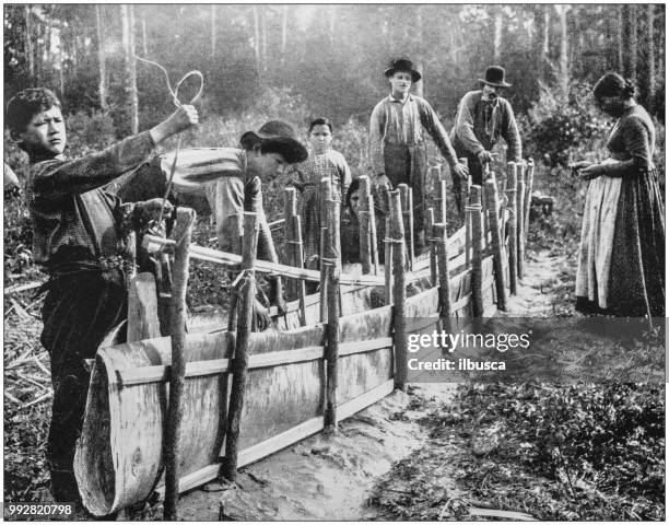 antique photograph of america's famous landscapes: chippewa indians, wisconsin, building a canoe - ojibwe stock illustrations