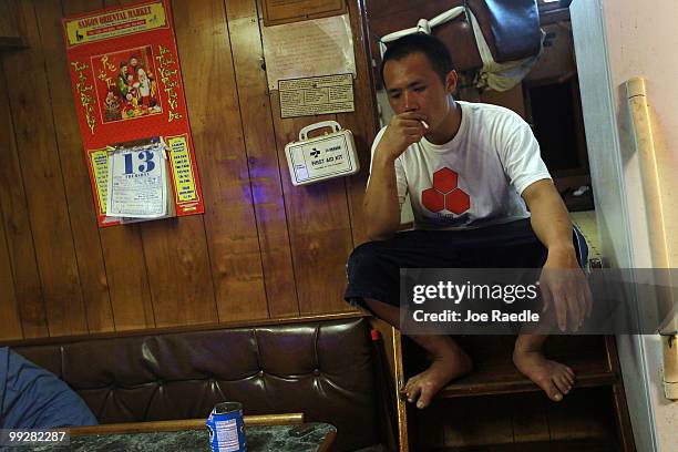 Tin Nguyen passes time away in the shrimp boat he works on after the owner shut down operations due to the massive oil spill in the Gulf of Mexico on...