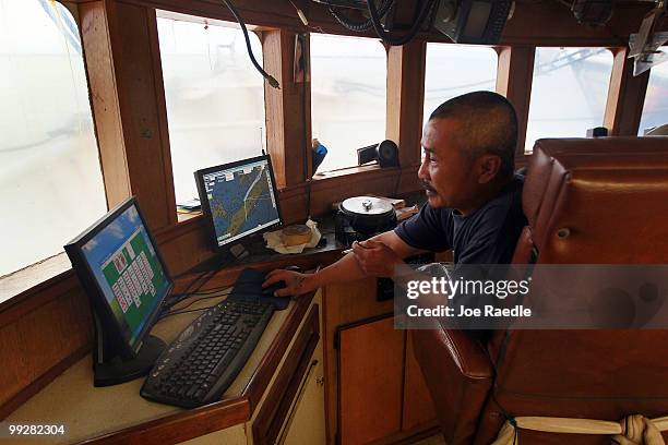 Fallguy Lee plays solitaire on a computer as he passes time away in the shrimp boat he works on after the owner shut down operations due to the...