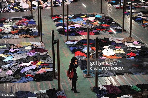 Woman photographs part of French artist Christain Boltanski's "No Man's Land", composed of 30 tons of discarded clothing on display May 13, 2010 at...