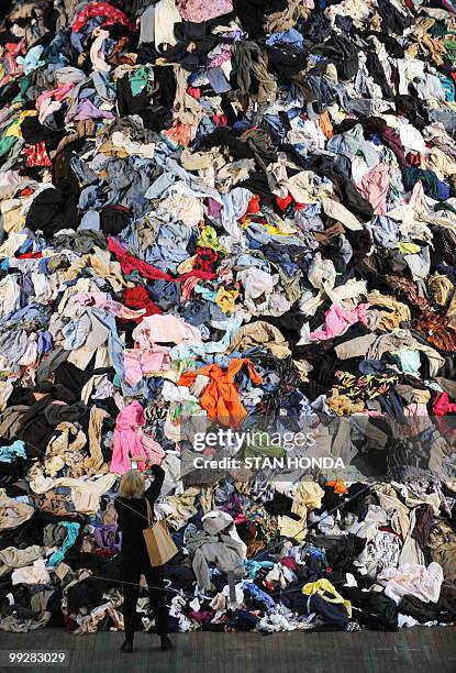 Woman photographs French artist Christain Boltanski's "No Man's Land", composed of 30 tons of discarded clothing, on display May 13, 2010 at the Park...