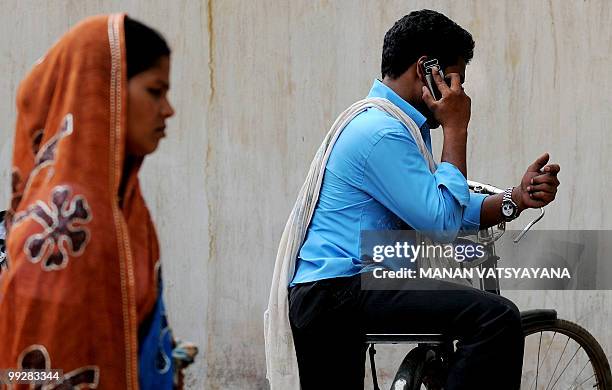 India-unrest-Maoist-media,FEATURE by Pratap Chakravarty In this picture taken on April 23 an Indian cyclist talks on his cellular telephone in the...