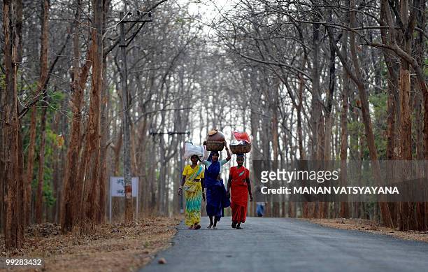 India-Maoist-unrest-forests-economy,FEATURE by Pratap Chakravarty Indian tribal women carry household goods from a weekly market in the village of...