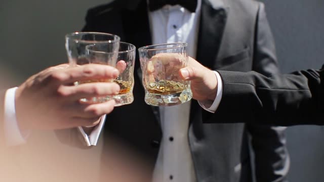 The groom and his friends drink whiskey
