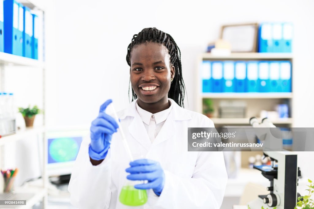 Female microbiologyst pipetting in laboratory