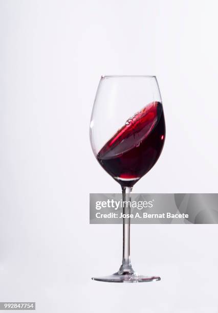 red wine splashing in glass in front of white background. - 高速度撮影 ストックフォトと画像