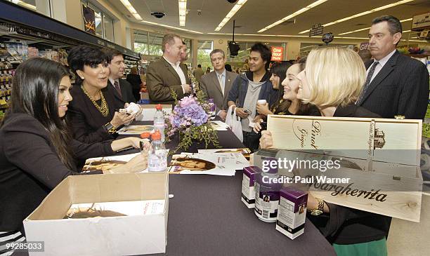 Kourtney Kardashian and Kris Jenner receive a bottle of wine as a gift from a winemaker at the Rejuvicare launch at Walgreens on May 13, 2010 in Lake...