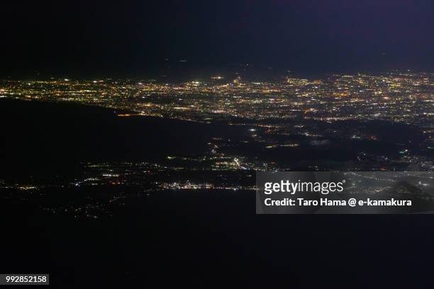 tokyo bay, sagami bay and miura peninsula in kanagawa prefecture in japan night time aerial view from airplane - chigasaki stockfoto's en -beelden