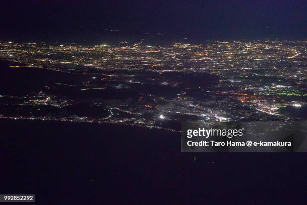 tokyo bay, sagami bay and miura peninsula in kanagawa prefecture in japan night time aerial view from airplane - chigasaki stockfoto's en -beelden