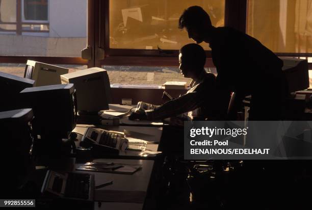 Un homme en fauteuil roulant dans un environnement de bureau en novembre 1989 en France.