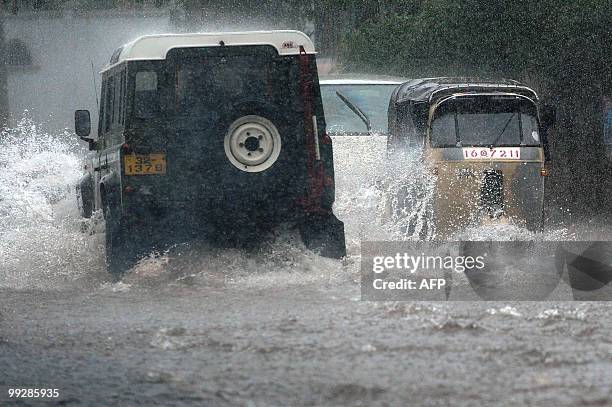Vehicles drive along a flooded street in Colombo on May 14, 2010. The capital city was lashed by heavy rains causing majot traffic jams throughout...