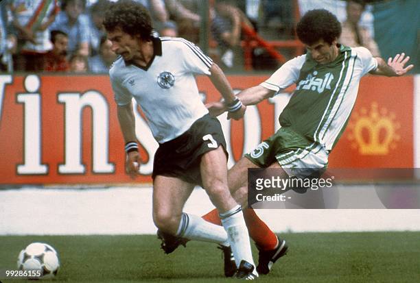 West German defender Paul Breitner tries to control the ball under pressure from Algerian midfiedler Mustapha Dahleb during the World Cup first round...