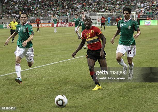 Jose Alberto Mabina of Angola slips past Paul Aguilar and Jonny Magallon of Mexico during the friendly international match between Mexico and Angola...