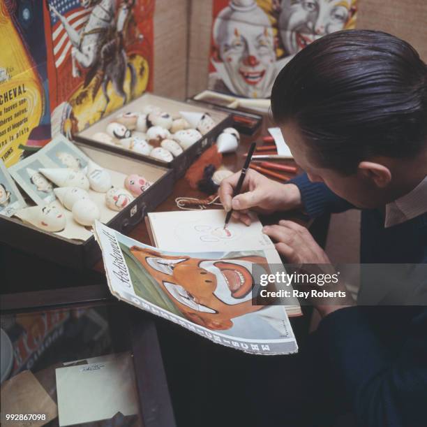 Egg painter Jack Cough copying a clown's face into his notebook to indexing clowns' faces, London, UK, January 1967.