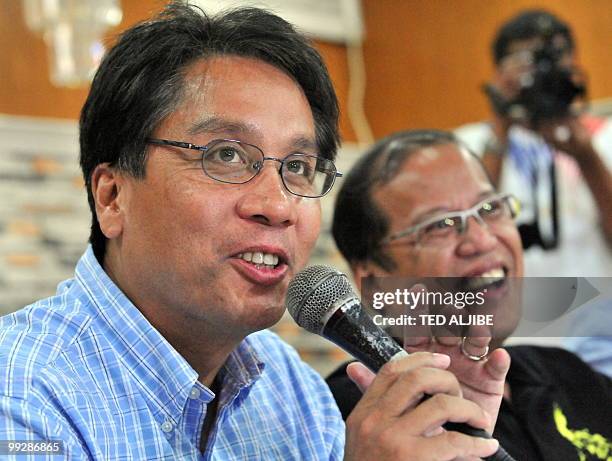 Philippine Liberal Party leading presidential candidate Benigno Aquino smiles as his vice-presidential running mate Mar Roxas speaks during a press...