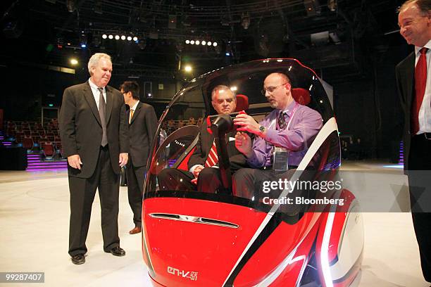 Mike Robinson, General Motors Co.'s vice president of Environment and Energy, left, U.S. Secretary of Transportation Ray LaHood, in vehicle at left,...