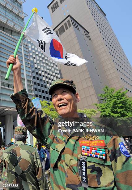 South Korean army veteran protests holding a national flag during a rally in Seoul on May 14, 2010 to accuse North Korea of sinking a South Korean...