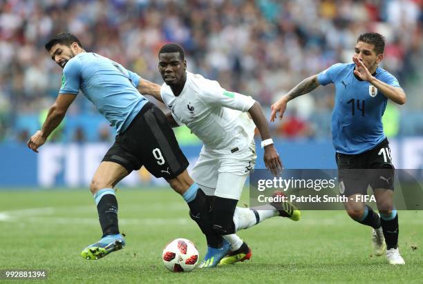 Paul Pogba of France is challenged by Lucas Torreira and Luis Suarez of Uruguay during the 2018 FIFA World Cup Russia Quarter Final match between...