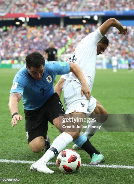 Raphael Varane of France is tackled by Cristian Rodriguez of Uruguay during the 2018 FIFA World Cup Russia Quarter Final match between Uruguay and...